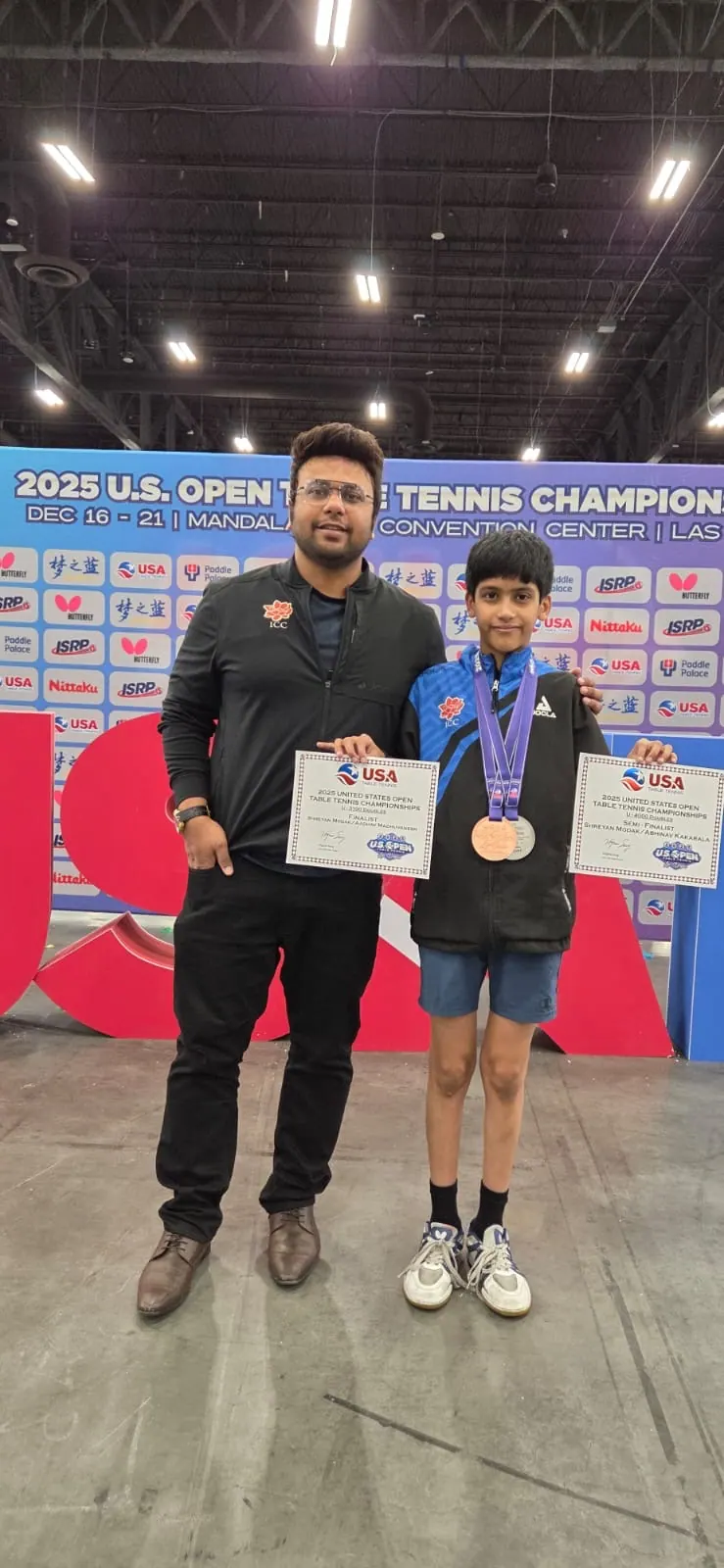 Shreyan Modak with his bronze medal and two USATT certificates beside Subham Kundu at the 2025 US Open