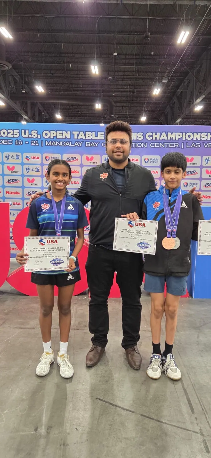 Two medallists holding certificates beside Subham Kundu at the 2025 US Open